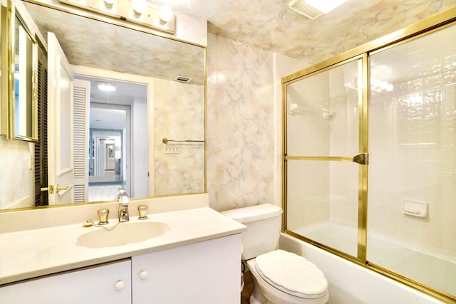 full bathroom featuring combined bath / shower with glass door, vanity, and toilet