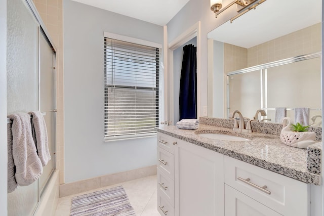 bathroom featuring vanity, tile patterned floors, and bath / shower combo with glass door