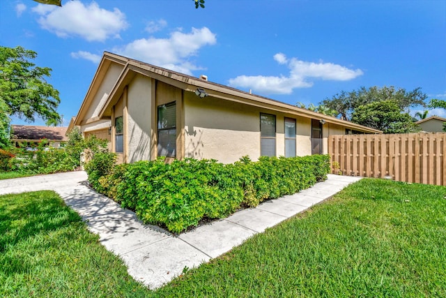 view of side of home with a yard