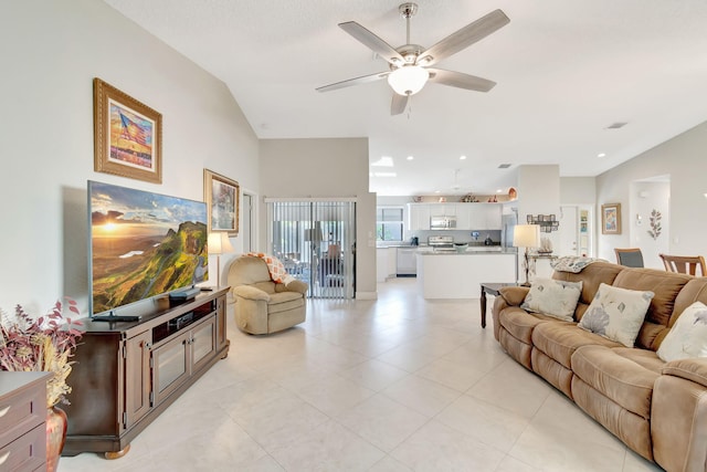 living room featuring lofted ceiling, ceiling fan, and light tile patterned flooring