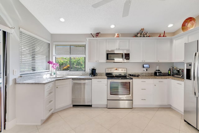 kitchen with ceiling fan, stainless steel appliances, white cabinetry, and sink