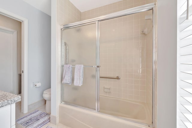 full bathroom with combined bath / shower with glass door, vanity, toilet, and tile patterned floors