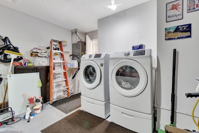 clothes washing area featuring a textured ceiling, ceiling fan, and washer and dryer