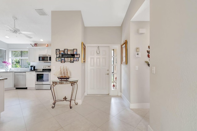 tiled foyer featuring ceiling fan and sink