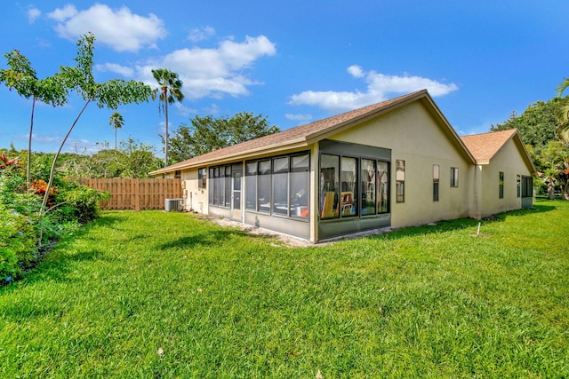 back of property featuring a yard, central AC unit, and a sunroom