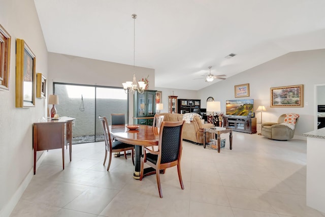 dining space featuring ceiling fan with notable chandelier, light tile patterned flooring, and vaulted ceiling