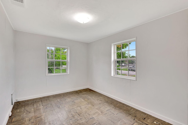 unfurnished room with light parquet floors and plenty of natural light