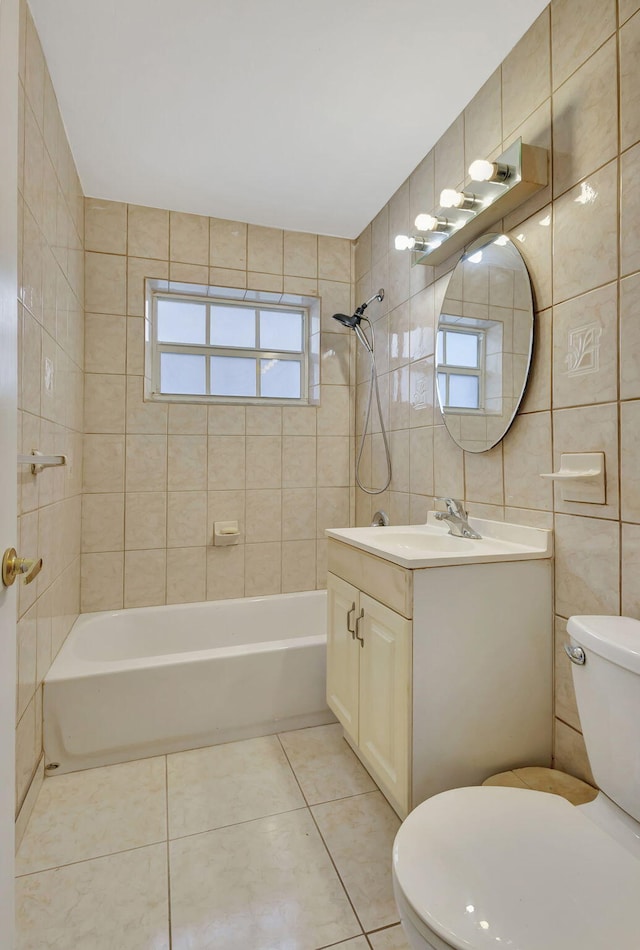 full bathroom with tile walls, tiled shower / bath combo, tile patterned floors, and toilet