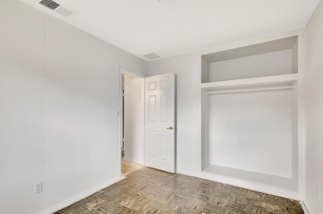 unfurnished bedroom with light parquet floors and a closet