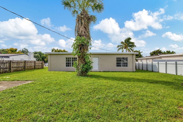 rear view of property with a lawn