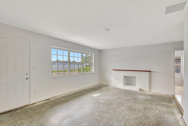 unfurnished living room featuring a textured ceiling and a fireplace