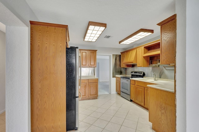 kitchen featuring stainless steel appliances, sink, light tile patterned flooring, and premium range hood