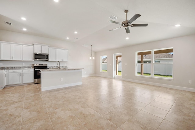 kitchen featuring lofted ceiling, white cabinets, ceiling fan, appliances with stainless steel finishes, and light stone counters