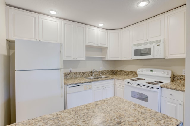 kitchen featuring sink, white cabinetry, and white appliances