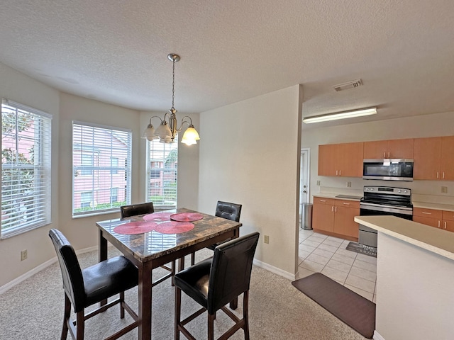 dining area with visible vents, a textured ceiling, an inviting chandelier, baseboards, and light colored carpet