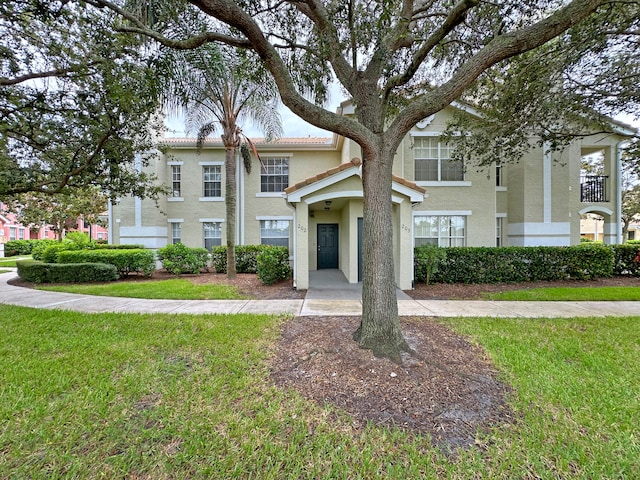 view of front of house featuring a balcony and a front yard