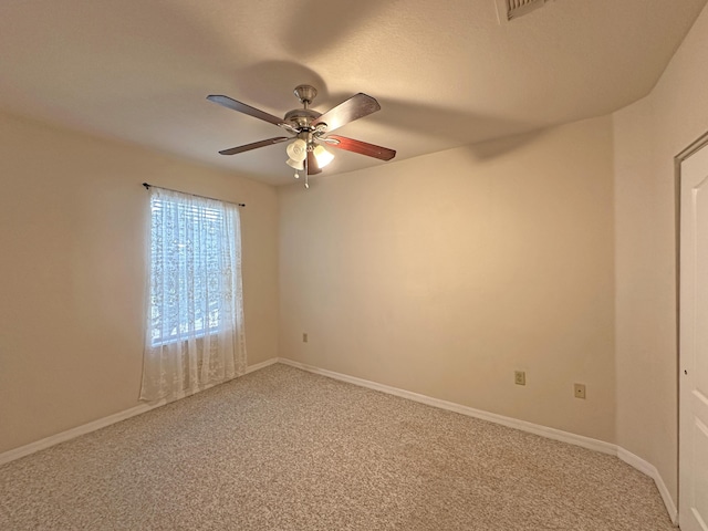 empty room with light colored carpet, baseboards, and ceiling fan