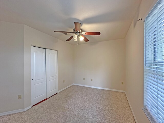 unfurnished bedroom featuring ceiling fan, carpet, and a closet