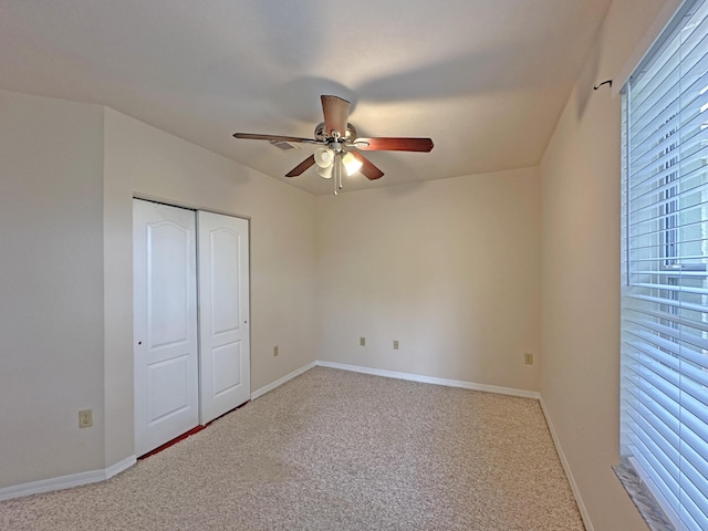 unfurnished bedroom featuring a closet, baseboards, carpet, and a ceiling fan