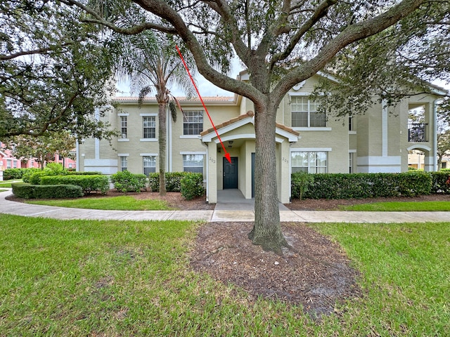 view of front of property with a balcony and a front lawn