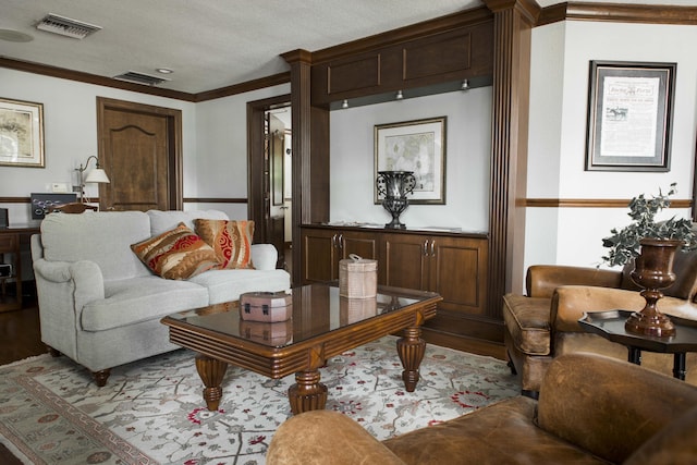 living area with visible vents, crown molding, and wood finished floors