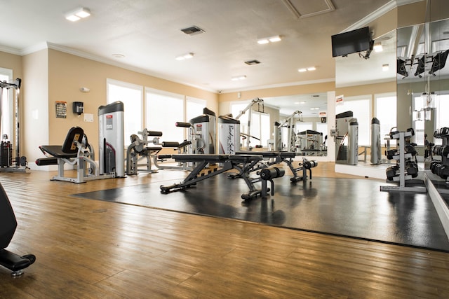 gym featuring visible vents, wood finished floors, and crown molding