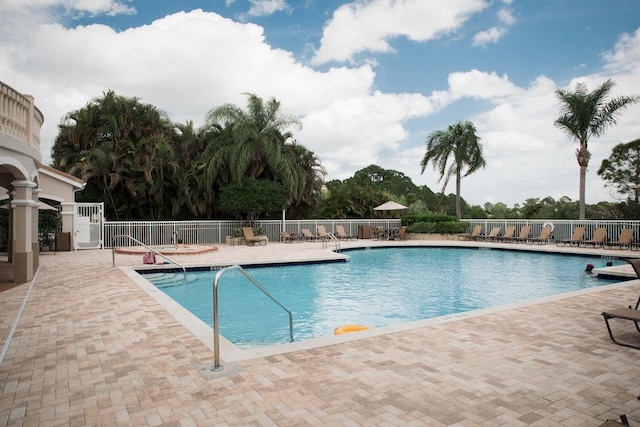 community pool with a patio and fence