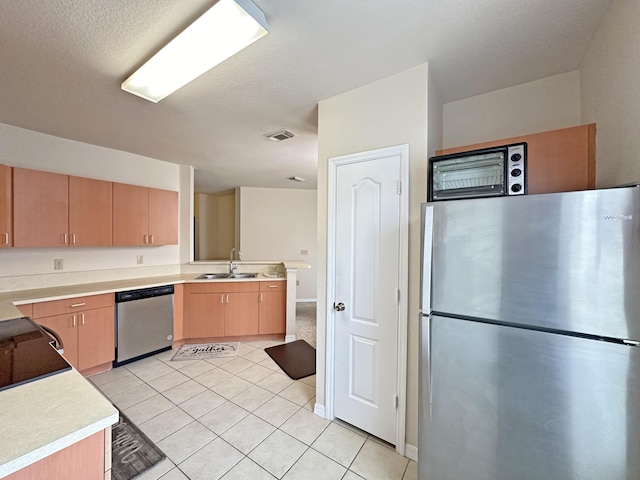 kitchen with visible vents, light brown cabinets, light countertops, stainless steel appliances, and a sink