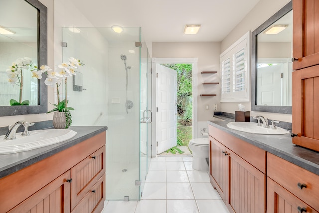 bathroom with vanity, toilet, a shower with shower door, and tile patterned floors