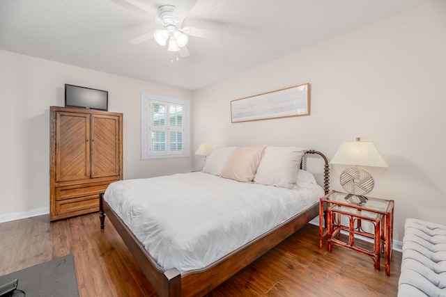 bedroom featuring ceiling fan, dark hardwood / wood-style flooring, and a textured ceiling