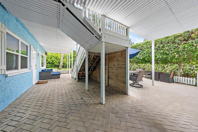 view of patio featuring outdoor dining space, stairway, fence, and an outdoor living space