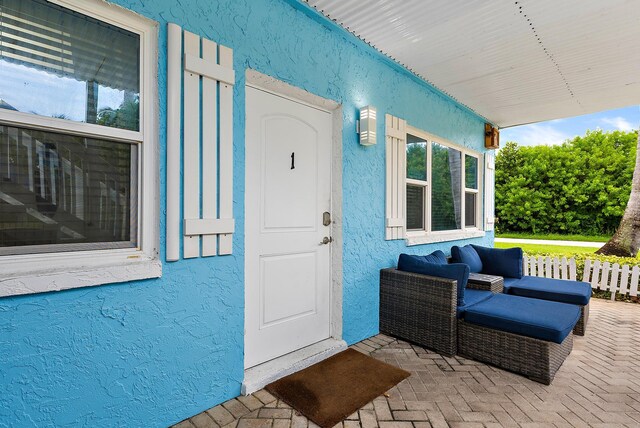 entrance to property featuring radiator, covered porch, and stucco siding