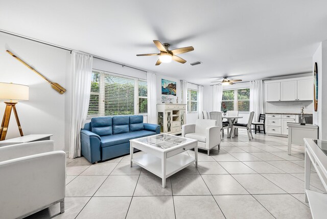 living area with light tile patterned floors, visible vents, and a ceiling fan