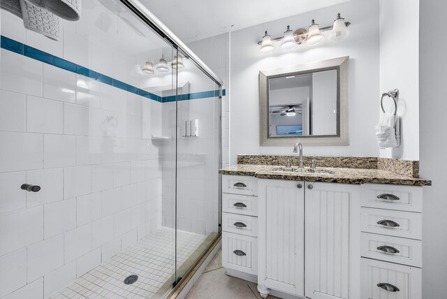 full bath with tile patterned flooring, a shower stall, and vanity