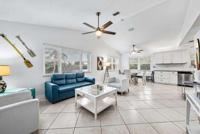 living room featuring light tile patterned floors, visible vents, vaulted ceiling, and a ceiling fan