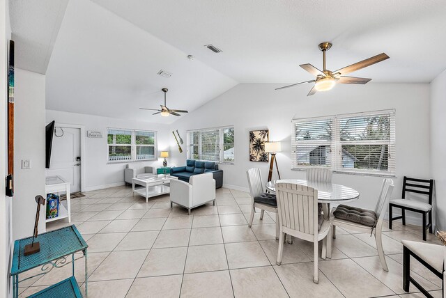 living area with light tile patterned floors, visible vents, baseboards, ceiling fan, and vaulted ceiling