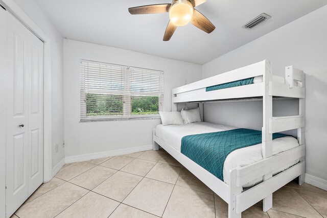 bedroom with light tile patterned floors, a ceiling fan, visible vents, and baseboards