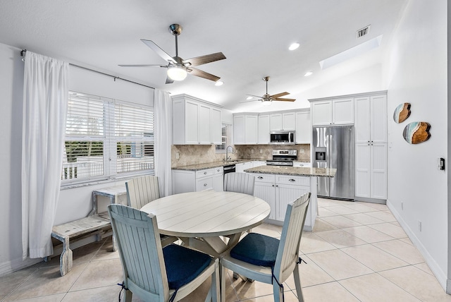 kitchen with stainless steel appliances, tasteful backsplash, a sink, and light tile patterned floors