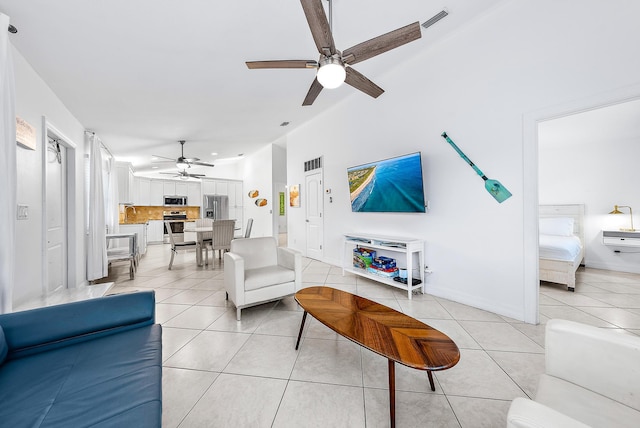 living room with lofted ceiling, ceiling fan, visible vents, and light tile patterned flooring