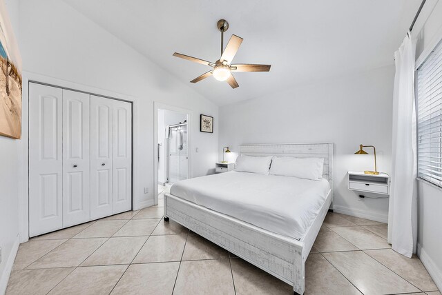 bedroom with light tile patterned floors, baseboards, a ceiling fan, lofted ceiling, and a closet