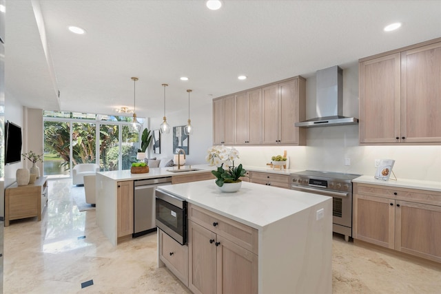 kitchen featuring stainless steel appliances, kitchen peninsula, wall chimney exhaust hood, decorative light fixtures, and a center island