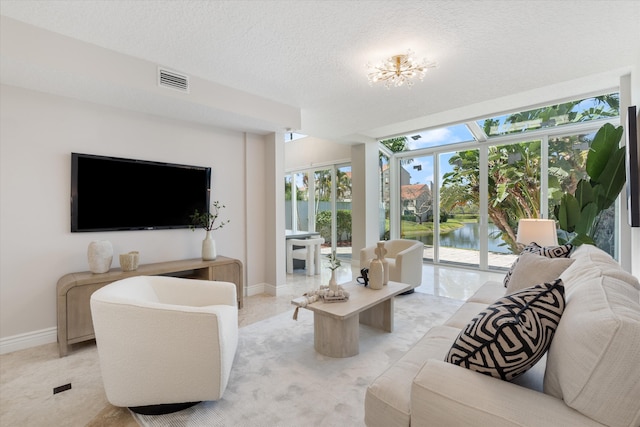 living room featuring a water view and a textured ceiling