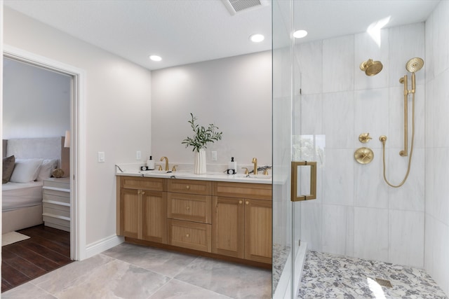 bathroom featuring hardwood / wood-style floors, vanity, and a tile shower