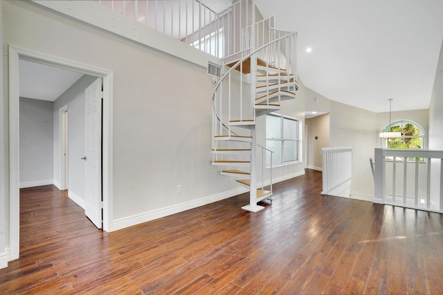 interior space with hardwood / wood-style flooring and a towering ceiling