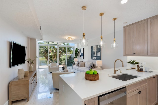 kitchen with light brown cabinetry, sink, and a textured ceiling