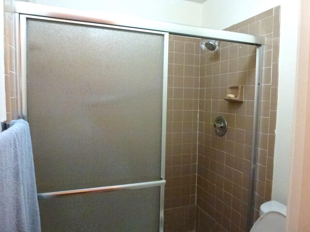 bathroom with an enclosed shower and toilet