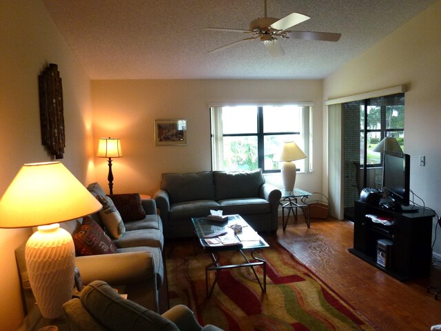 living room featuring a textured ceiling, ceiling fan, a healthy amount of sunlight, and hardwood / wood-style flooring