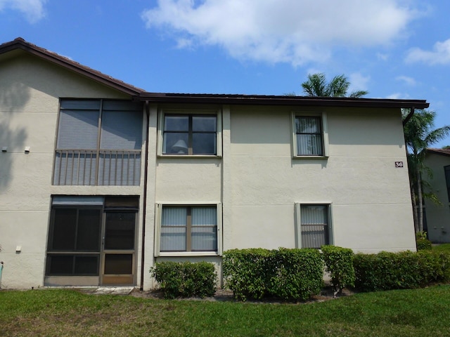 exterior space with a lawn and stucco siding