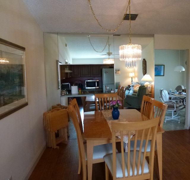 dining room featuring dark wood-style flooring, visible vents, and baseboards