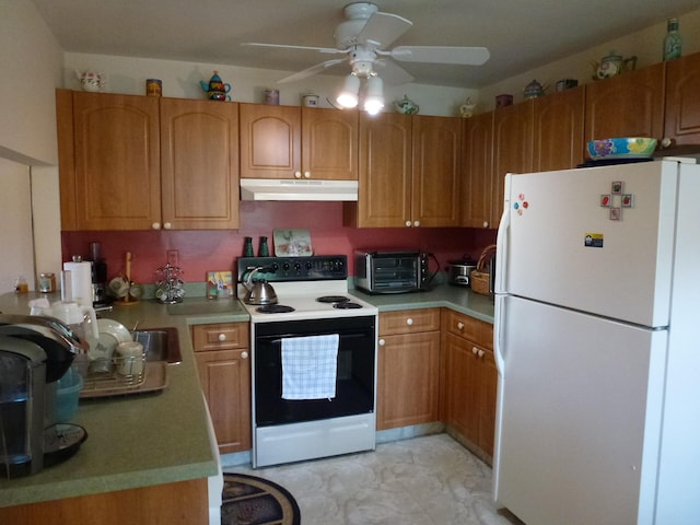 kitchen featuring electric range, a toaster, freestanding refrigerator, light countertops, and under cabinet range hood